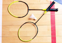 badminton rackets and shuttlecock resting on the court
