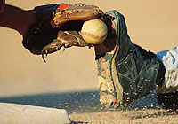 baseball player sliding onto base with a baseman ready to tag