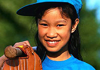 young female baseball player smiling and posing for the camera