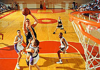 basketball game in progress, player jumping up for a shot at the basket