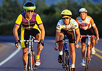 group of cyclists riding on the road