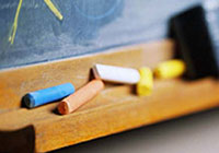 chalkboard, coloured chalk and an eraser in the background symbolizing sport education opportunities in Greater Sudbury