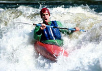 person kayaking down small rapids