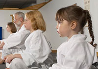 martial arts students of all ages listening to their instructor's words