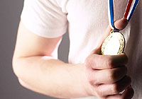 someone is holding a medal symbolizing Sudbury's sport community achieving great things in the community