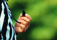 referee holding a whistle symbolizing sport in Greater Sudbury.