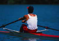 Man rowing across a calm lake