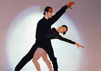 figure skating pair performing in the spotlight