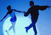 a pair of figure skaters performing in the spotlight