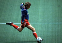 soccer player winding up to kick the ball