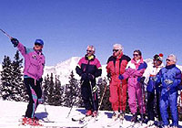 a group of cross country skiers led by a guide stop to listen to what their instructor is saying